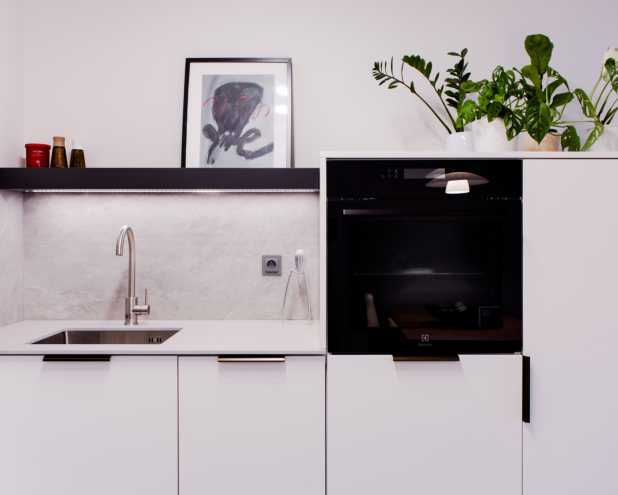 Półki z podświetleniem zamiast szafek wiszących, są lżejsze i delikatniejsze, a przydatne akcesoria kuchenne zawsze znajdują się pod ręką.